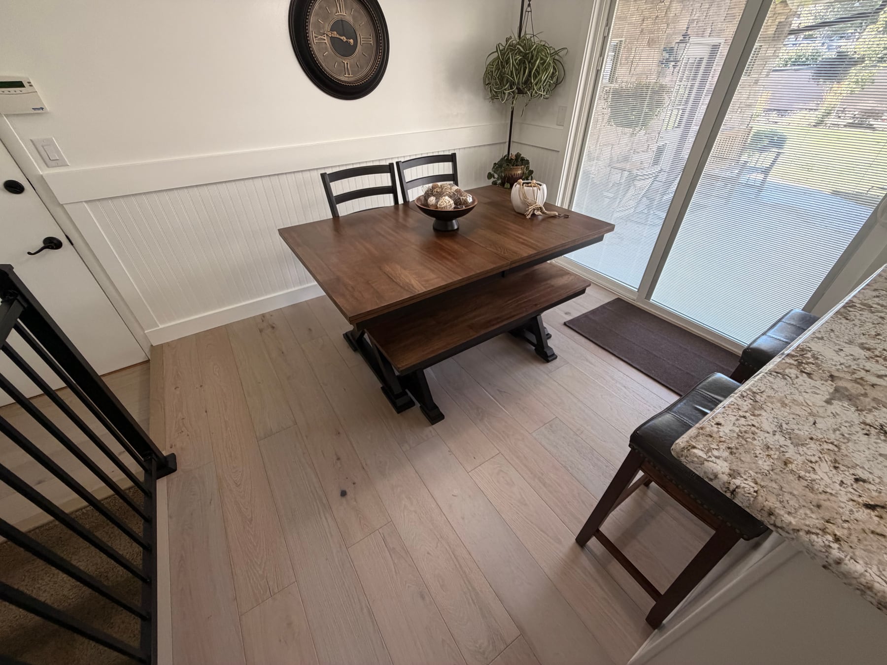 Finished dining area with new wood-look flooring and white beadboard trim