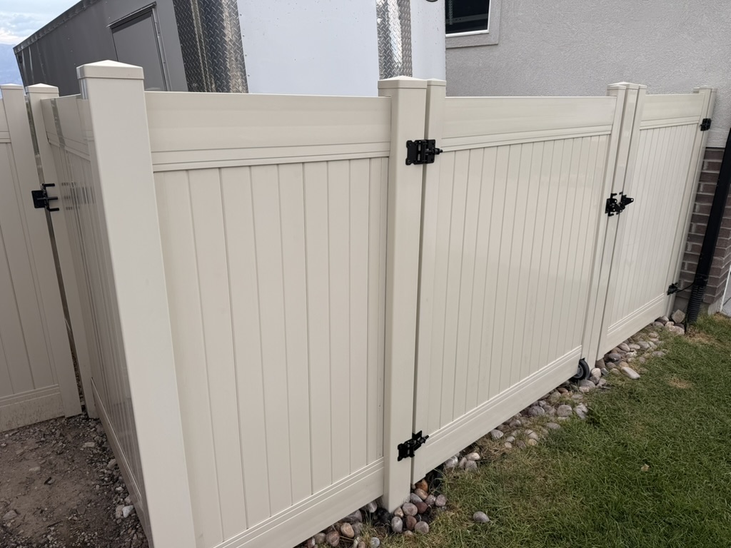 Detail view of the vinyl fence panels, posts, hinges, and gate latch